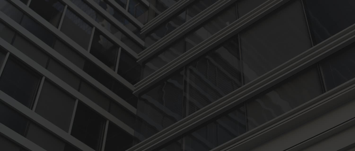 A mid-rise UK apartment building at dusk, dark glass facade